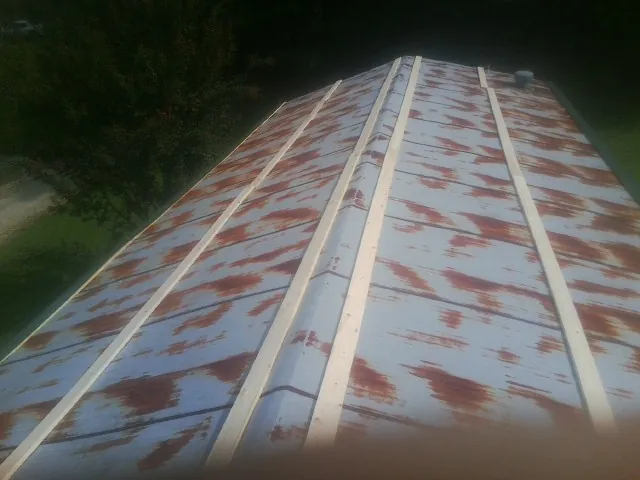 Rusted metal roof panels with new wood purlins before replacement — Storm Damage Roof Repair in Brentwood by Roofing Brothers